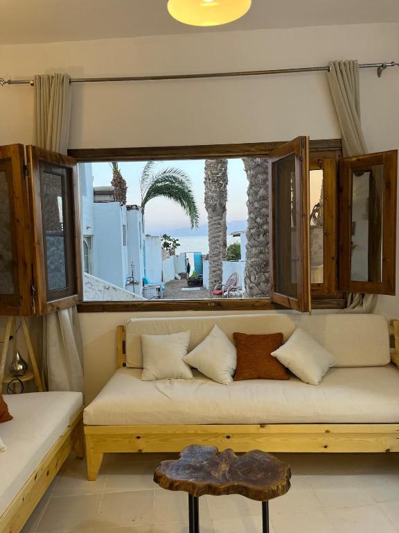a couch in a room with a large window at Oia seafront house in Dahab