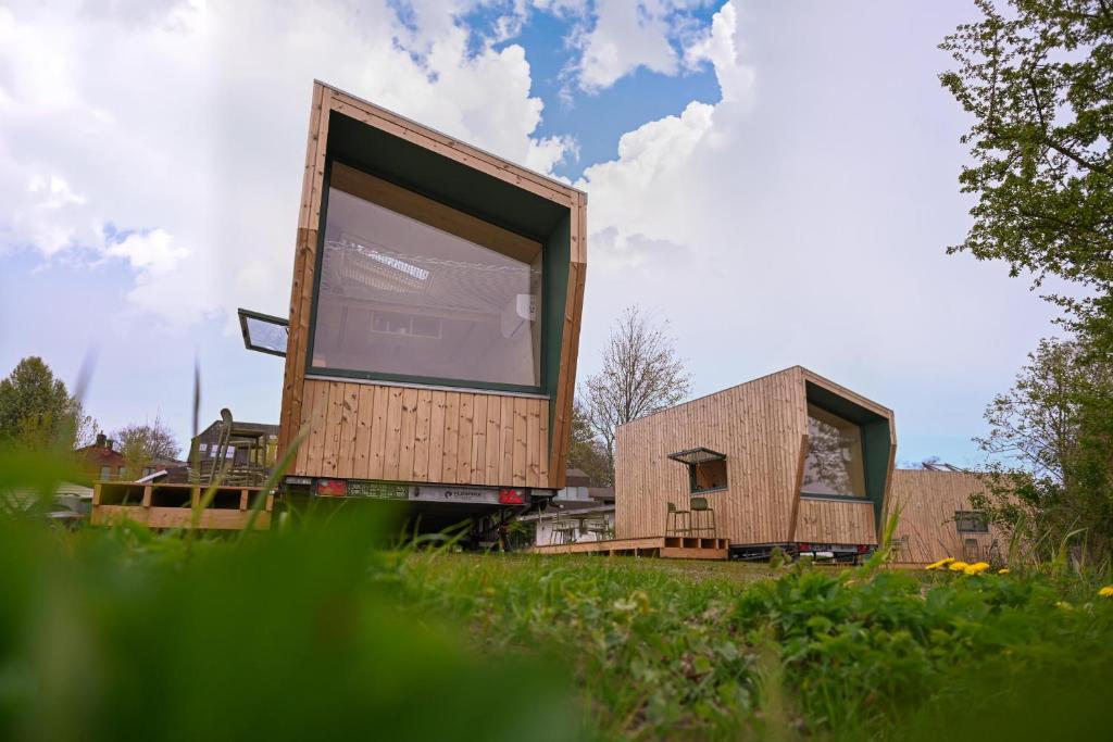 a small house sitting on top of a lush green field at Tiny House Nook 3 - Green&Tiny Hideaway Eider in Süderstapel