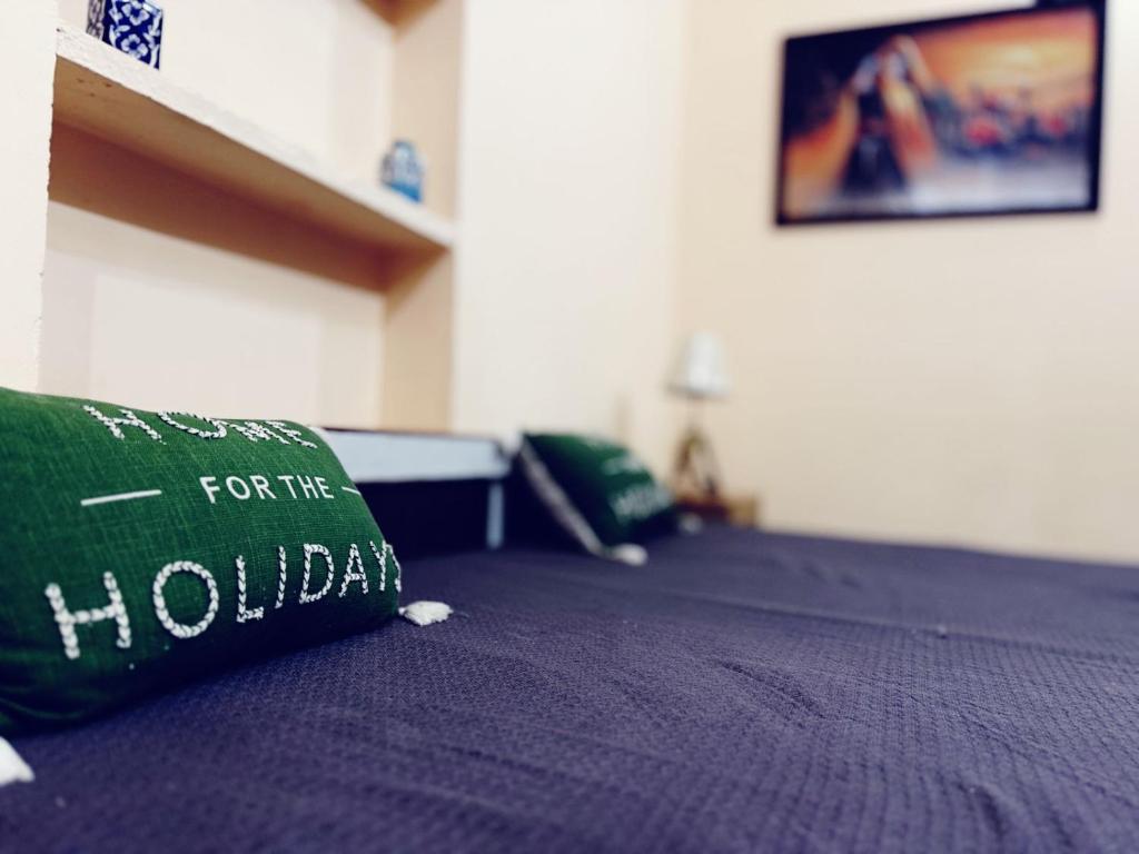 a bed with a green pillow on top of it at Sariska Haveli in Alwar