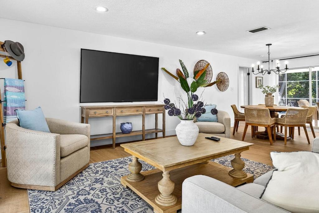 a living room with a tv and a table at Spacious Clearwater House 4BR 3BA Private Pool in Clearwater
