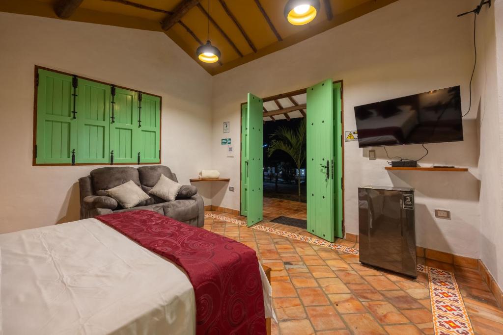a bedroom with green cabinets and a bed and a tv at Cabañas Campestres El Vaticano in Barichara