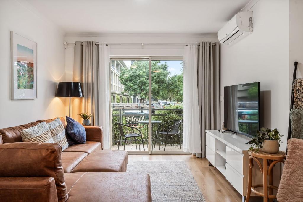a living room with a couch and a television at Carrington Views - 3 Bedrooms - CBD - Parking in Adelaide