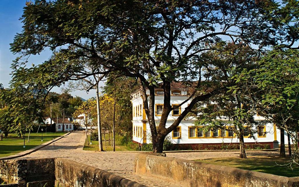a tree in front of a building with a clock on it at Solar da Ponte in Tiradentes