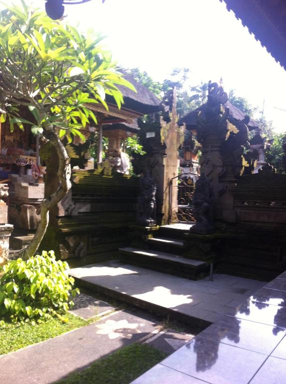 a stone building with stairs in a garden at Pondok Bali in Ubud