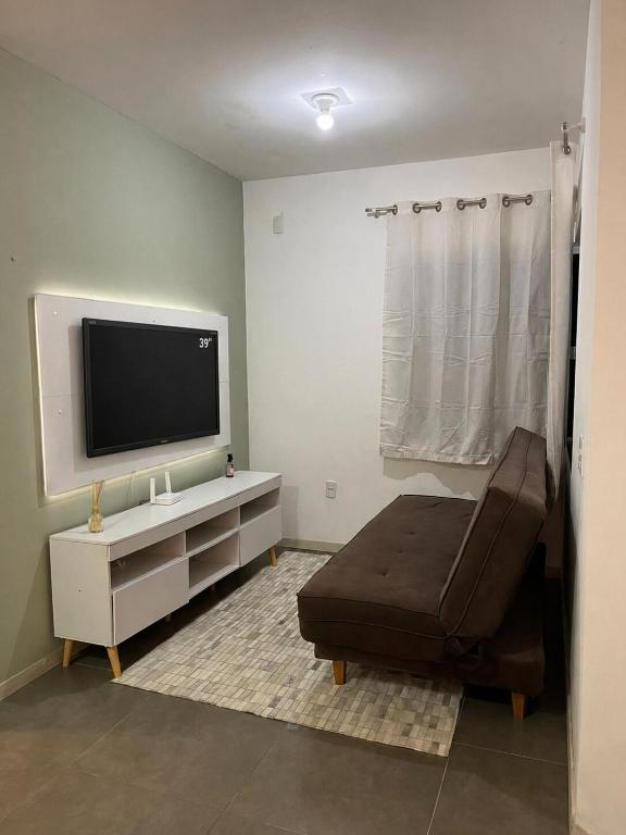a living room with a flat screen tv and a couch at Casa Goiaba in Piçarras