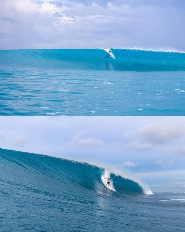 a person riding a wave on a surfboard in the ocean at Adams Villas in Katiet