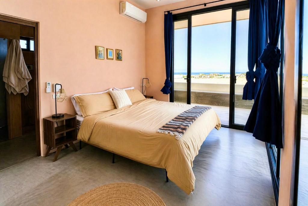 a bedroom with a large bed and a large window at Simple Stay, Big Views, Private Room & Pool in Todos Santos