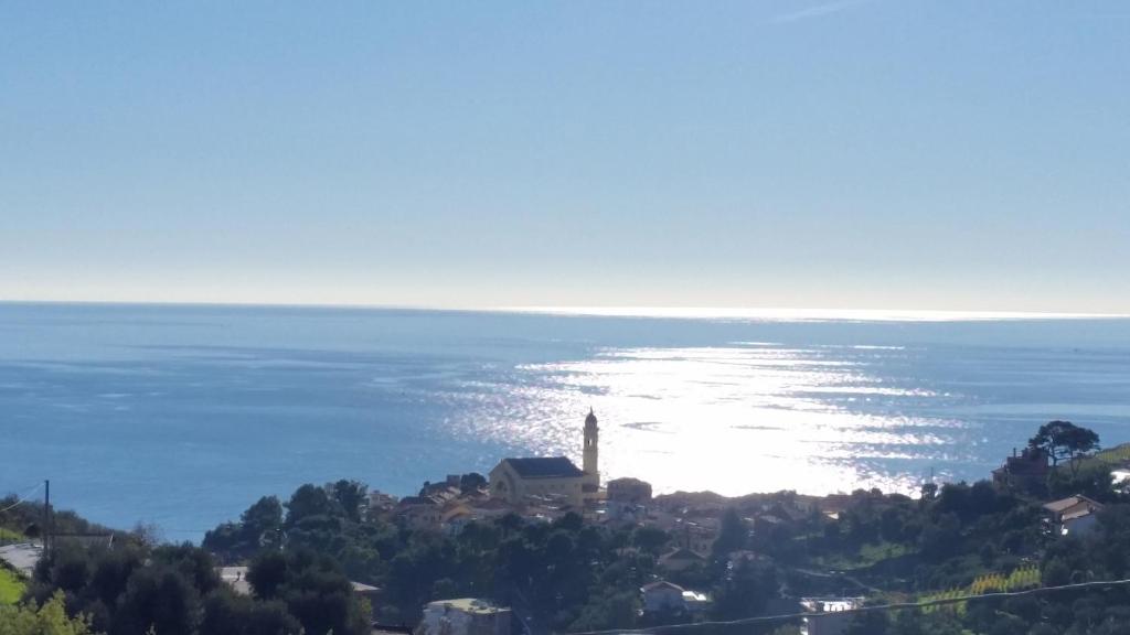 una vista del océano con una iglesia en una colina en B&B Ariadamare, en San Remo