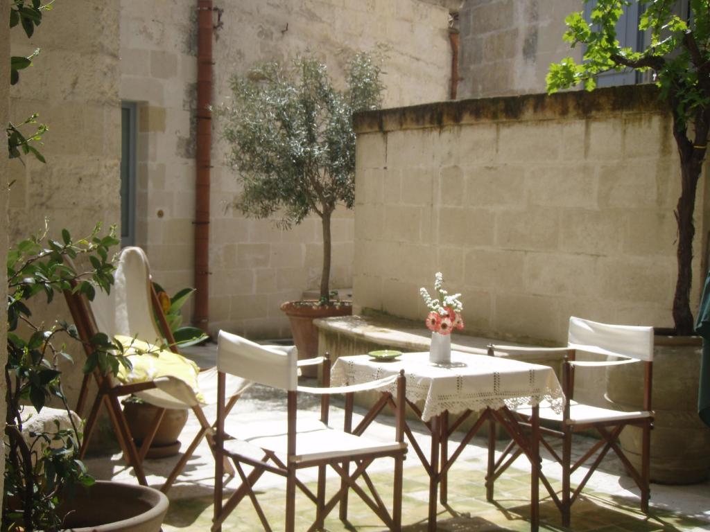 un patio con tavolo, sedie e piante di B&b Il Cortile a Matera