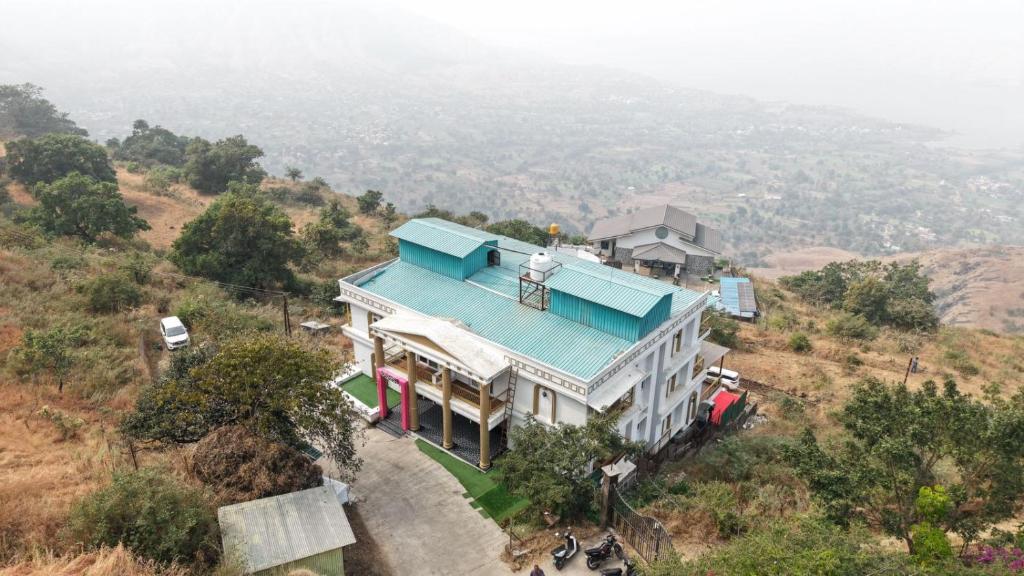 a house on a hill with a blue roof at The Mansion Resort And Spa in Panchgani