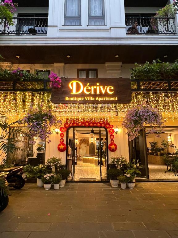 an entrance to a store with christmas lights and flowers at Dérive Boutique Villa & Apartment Da Nang in Danang