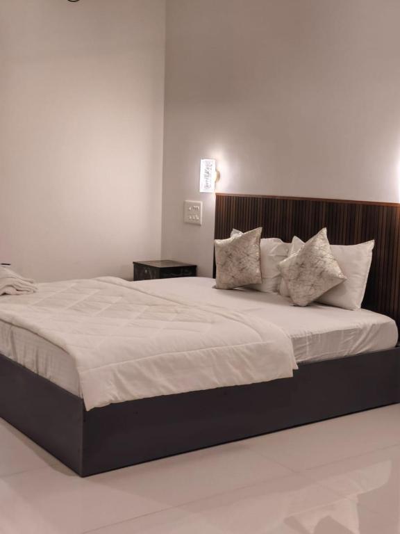 a bedroom with a large bed with white sheets and pillows at Myday Inn by Znormhomes in Varkala