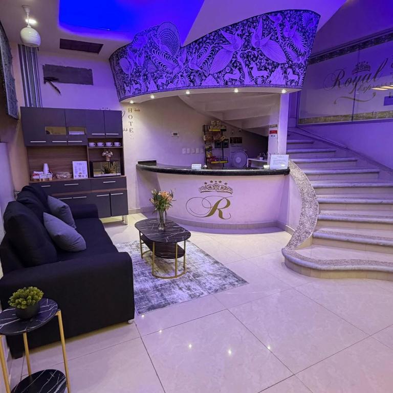 ein Wohnzimmer mit einer Couch und einer Treppe mit violetter Beleuchtung in der Unterkunft Royal Express Chilpancingo in Chilpancingo de los Bravos