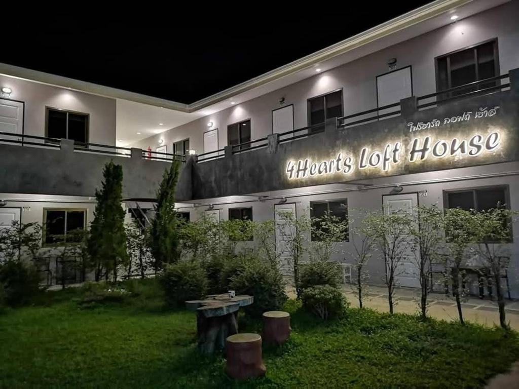 a building with a sign on the side of it at 4Hearts Hotel in Suratthani