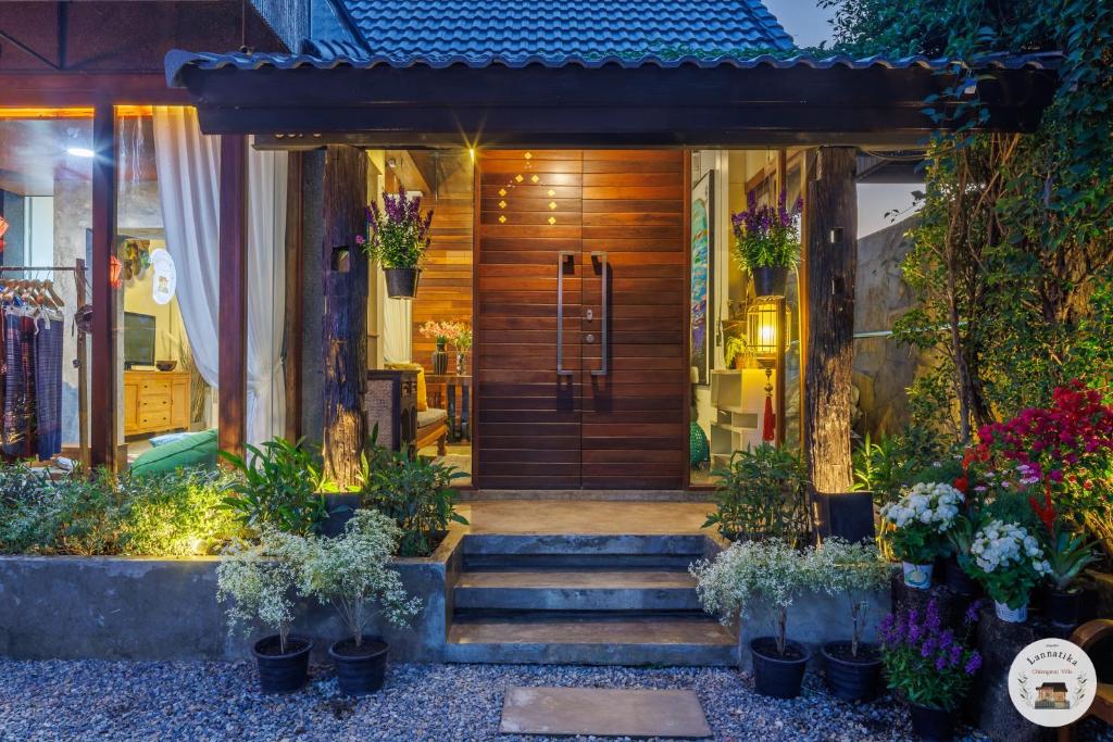 a front door of a house with flowers and plants at Lannatika Villa in Chiang Mai