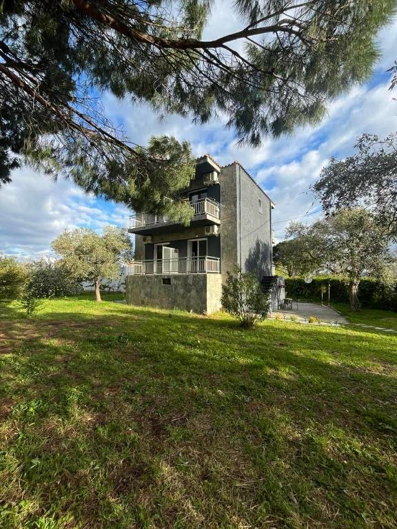 a house on a grassy field in front of a building at LaMar in Skala Prinou