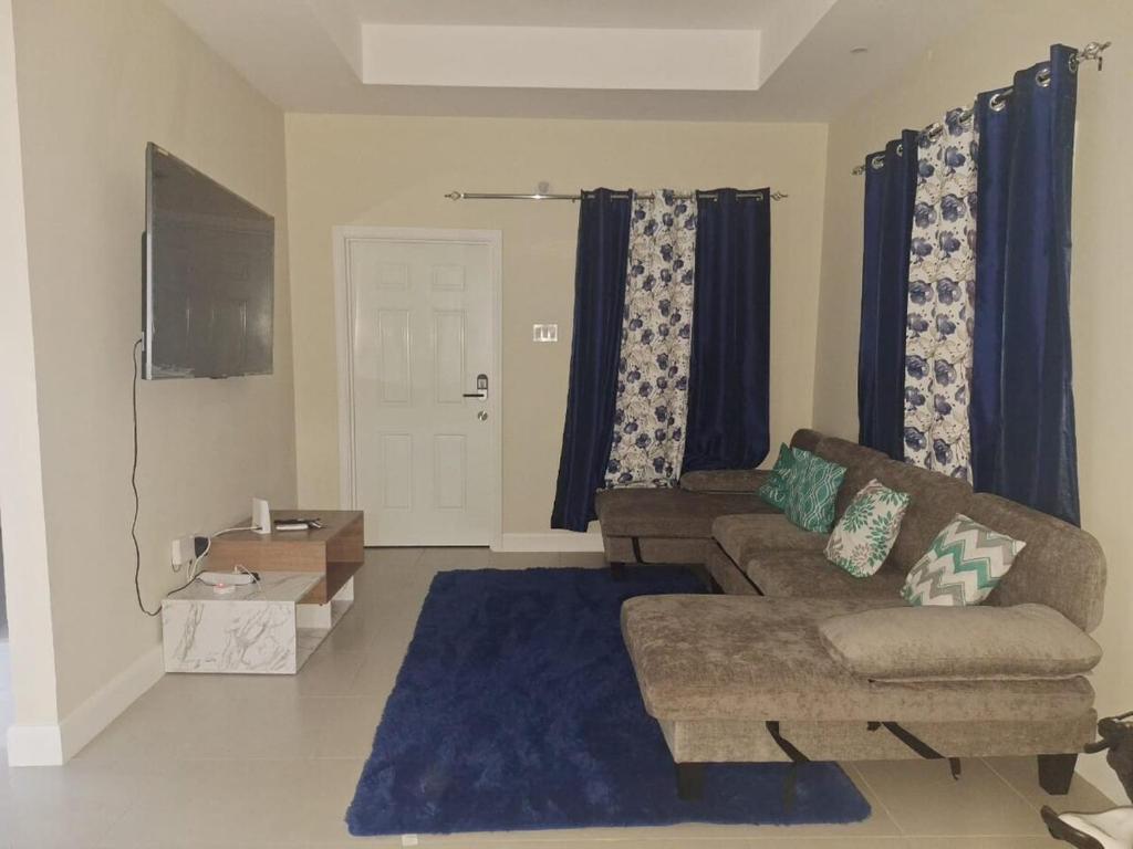a living room with a couch and a blue rug at The Cosy Home in Lucea