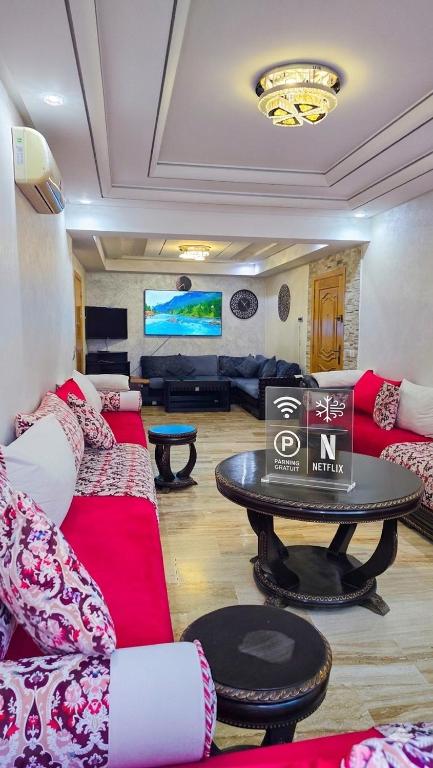 a living room with couches and a table with a tv at Spacious & chic - 3 min from Casa City Finance " CFC " in Casablanca