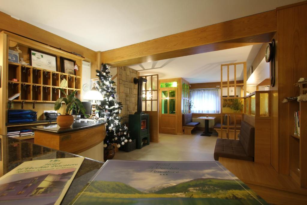 ヴィッレッタ・バッレーアにあるHotel Il Vecchio Pescatoreのリビングルーム(クリスマスツリー、テーブル付)