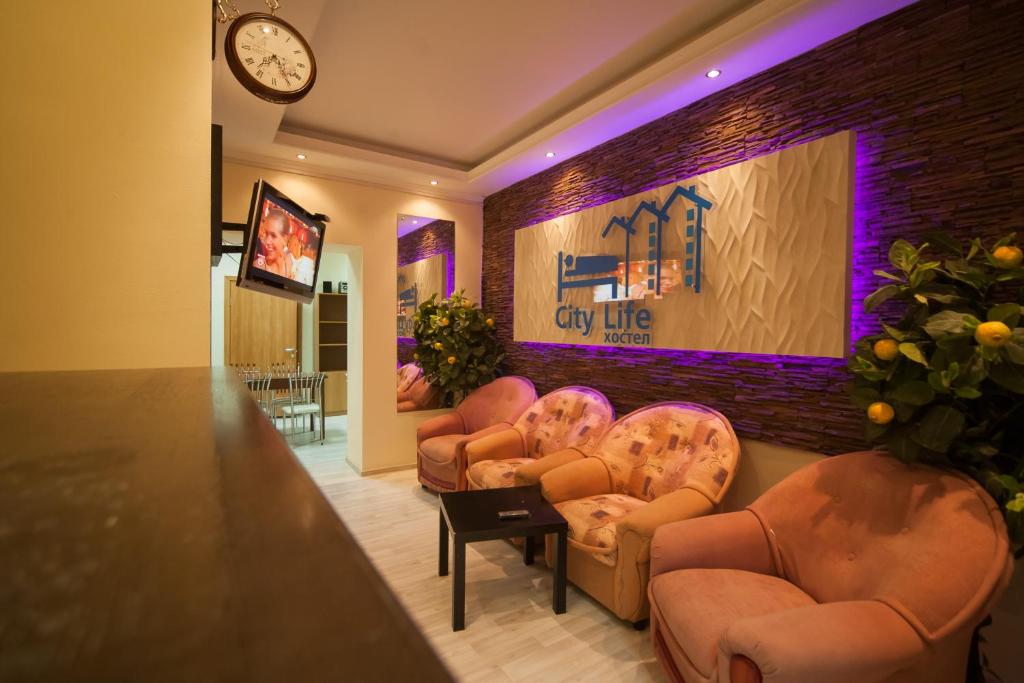 a waiting room with chairs and a wall with a clock at Hostel City Life in Tyumen