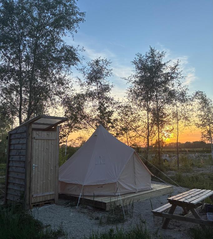 a tent and a picnic table in a field at Tipi du lac in Saint-Thibault