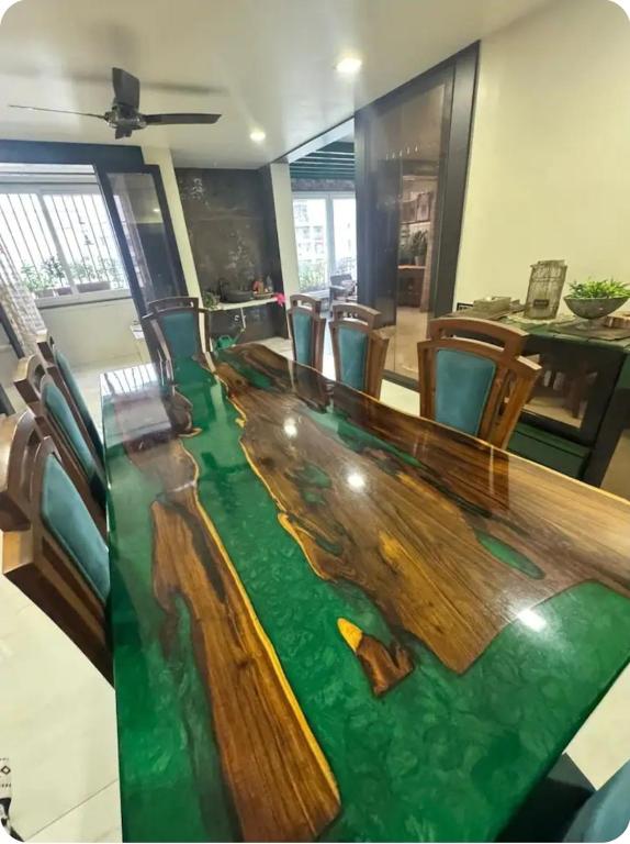 a conference room with a wooden table with green flooring at EVARA- Swaminarayan enclave in Nagpur