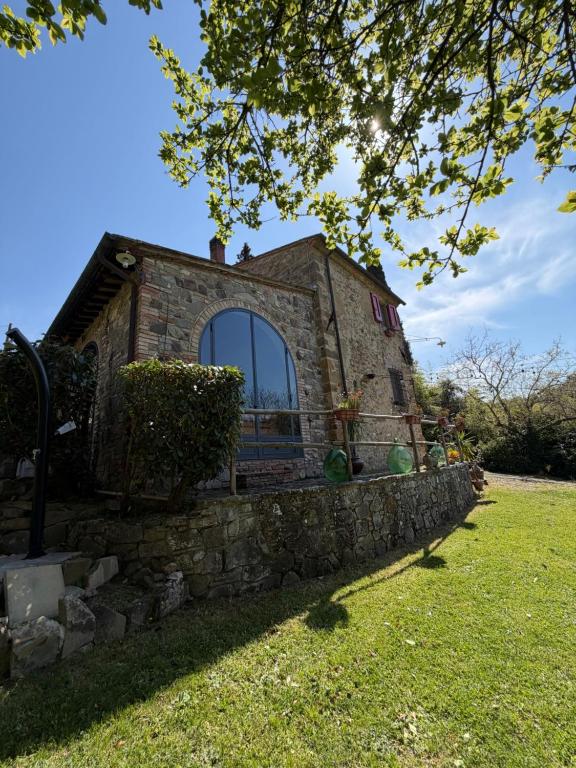 a stone building with a window in a yard at Casa nel bosco il Grottone in Montaione