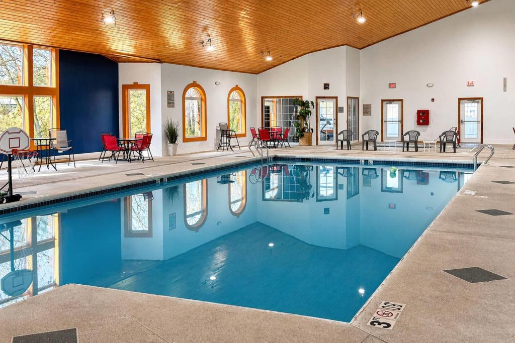 a swimming pool with blue water in a building at Comfort Suites Wisconsin Dells Area in Portage