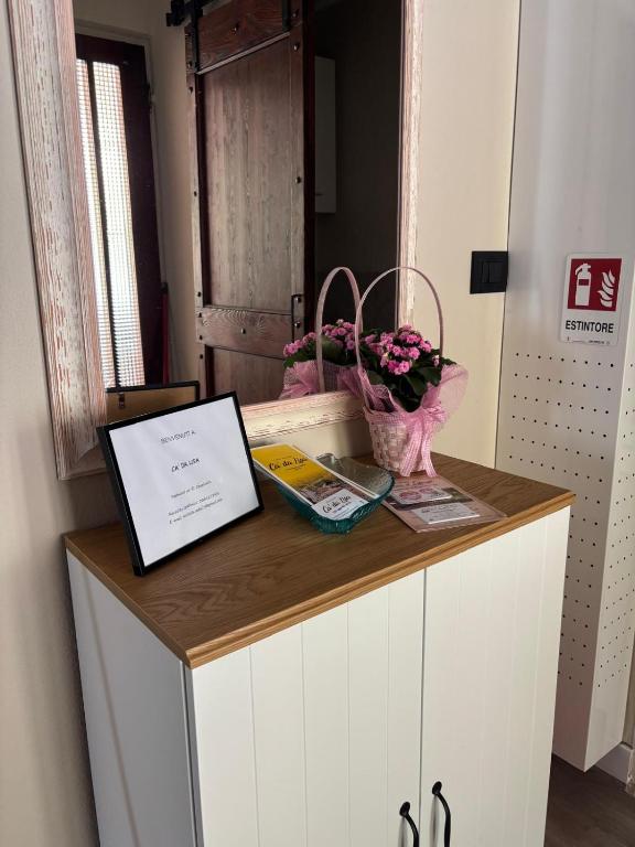 a desk with a laptop and flowers on it at Ca' da Lisa in San Colombano Certenoli