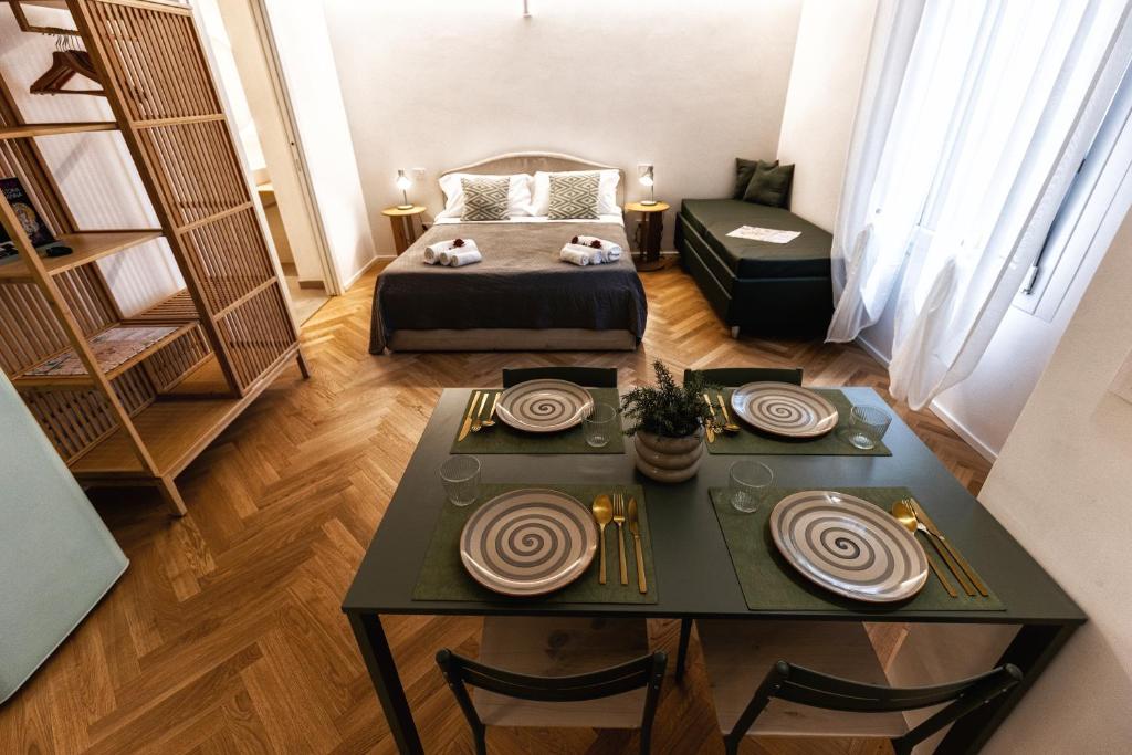 a room with a bed and a table with plates on it at Boccaccio Apartment 3 in Ravenna