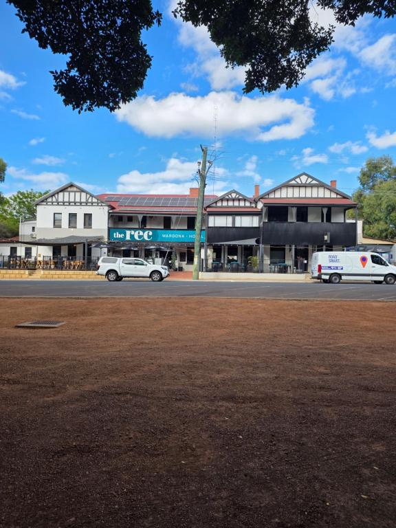 a street with two cars parked in front of a building at The Rec Hotel Waroona in Waroona