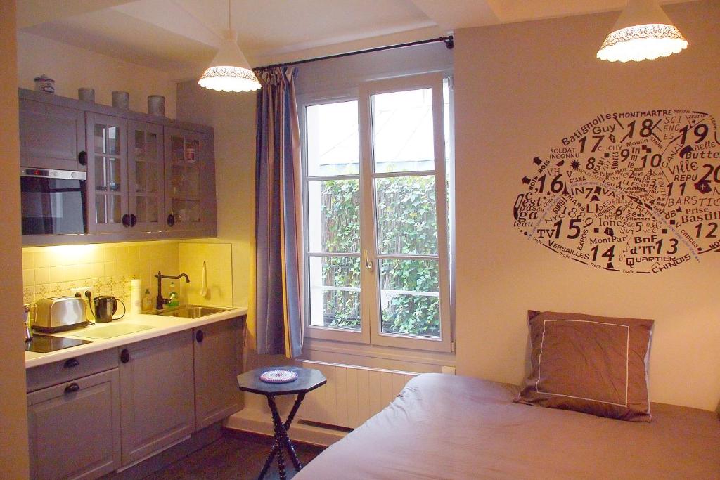 - une cuisine avec un lit, un évier et une fenêtre dans l'établissement Petit Paris - Oasis in Marais, à Paris