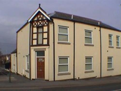 a large white building with a large window at Earle House Serviced Apartments in Crewe
