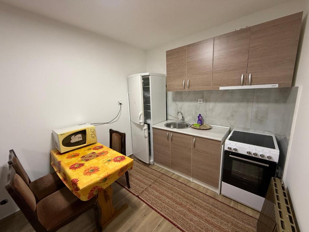 eine kleine Küche mit einem Tisch und einem Kühlschrank in der Unterkunft Apartman Katarina in Foča