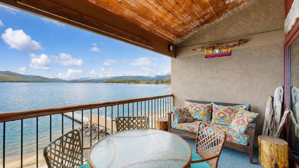 a balcony with a table and chairs and a view of the water at Lakeside Getaway Beach Access Shared Pool and Grills in McCall