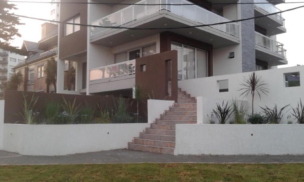 a house with a staircase in front of it at Avenida 1 in Villa Gesell