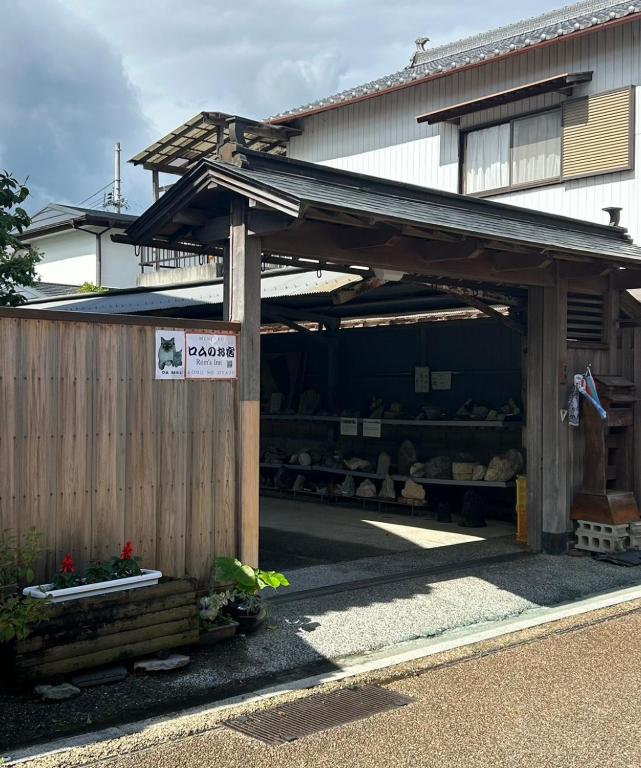 ein Gebäude mit einem Schuppen, an dem ein Schild befestigt ist in der Unterkunft Rom's Inn in Wakimachi