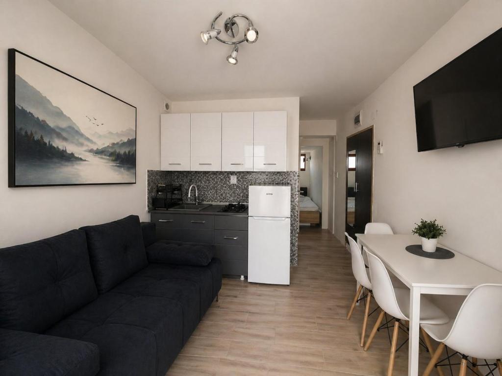 a living room with a couch and a table and a kitchen at Goga2 in Pirovac