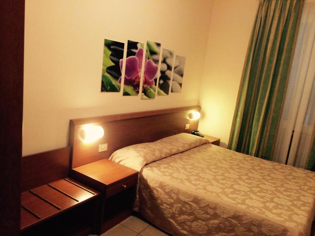 una habitación de hotel con una cama y una flor en la pared en Hotel Paradiso en Milán