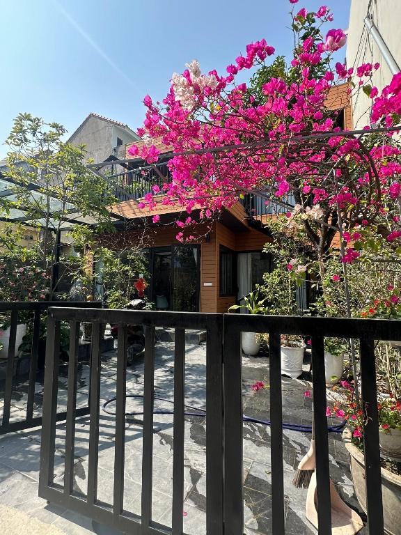 a house with pink flowers on a fence at Đông Hương Home in Cat Ba