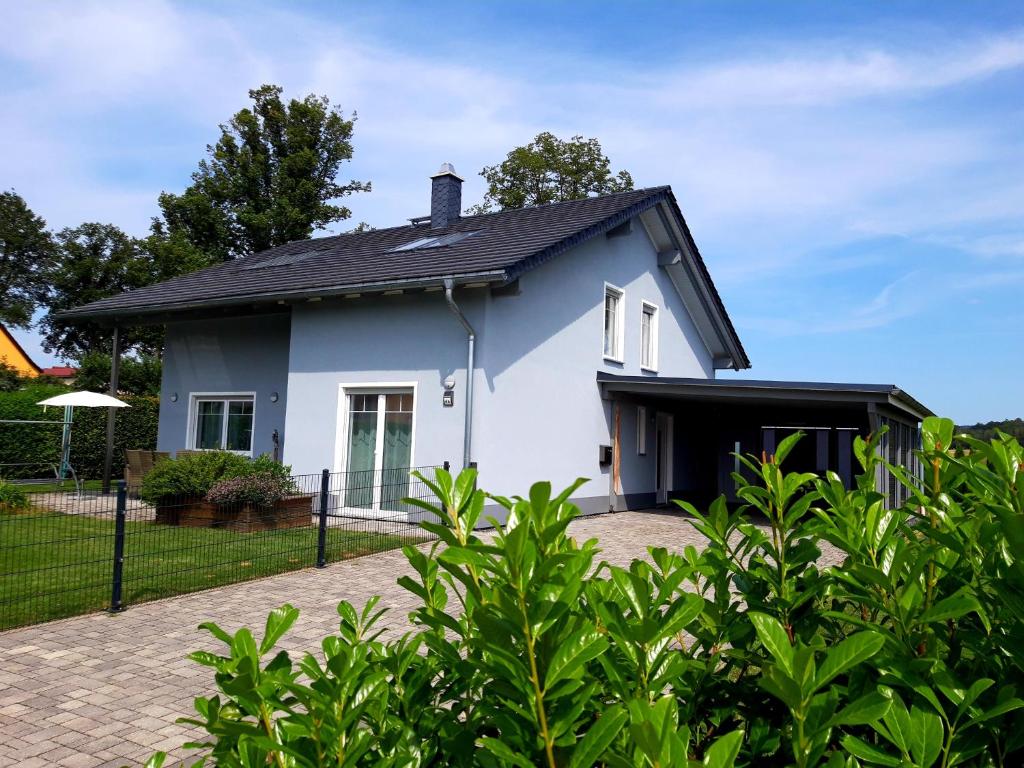 a white house with a black roof at Ferienoase Müller in Lichtenhain