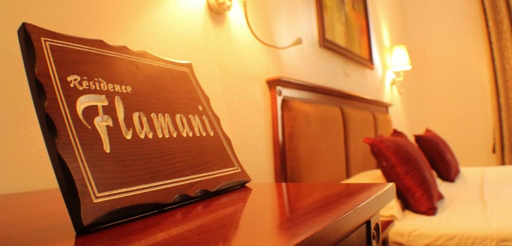 a sign on a table in a hotel room at Hotel Residence Flamani in Lomé