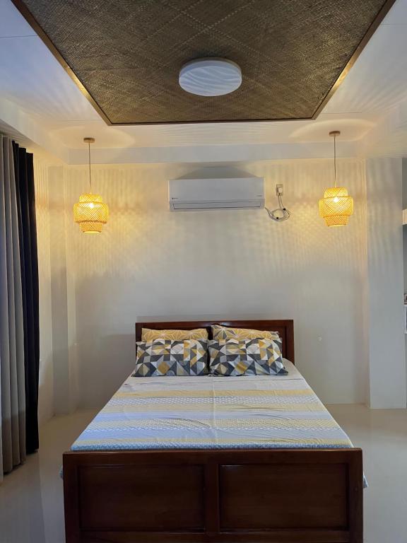 a bedroom with a bed with two lights on the ceiling at Beachfront Studio with Cozy and Spacious Balcony in Baling