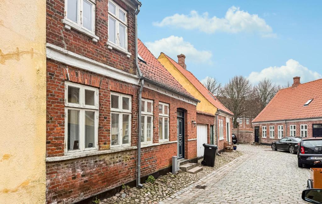 an alley in a brick building with cars parked on it at 4 Bedroom Awesome Home In Ribe in Ribe