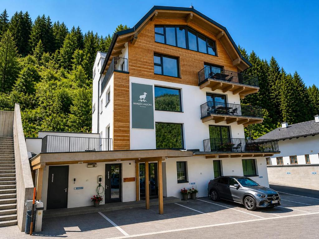 a building with a car parked in a parking lot at Bergschnucke homes - im Sommer inklusive Silvretta-Card in See