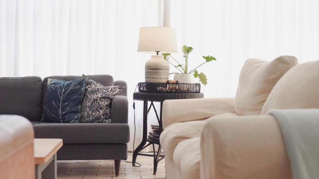 a living room with two couches and a lamp on a table at Rijke Rust, Living the Lagoon Life in Langebaan