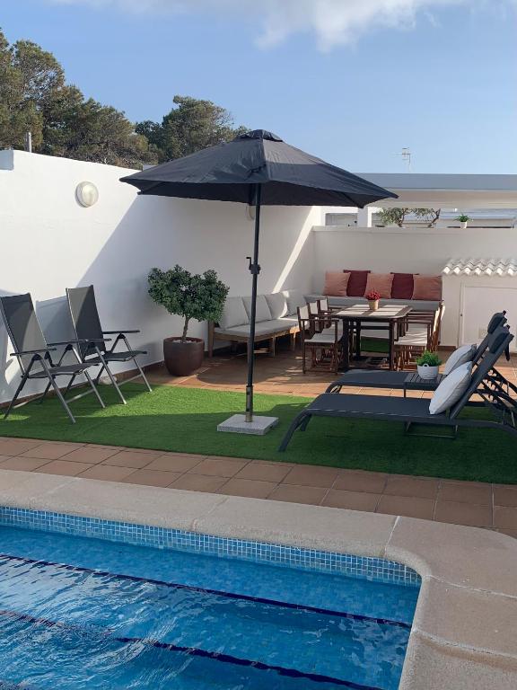 a patio with an umbrella next to a pool at LEIDA - Relax y privacidad in Cala Blanca