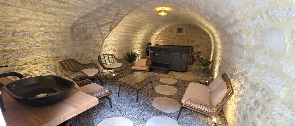 a room with a tub and chairs and a fireplace at Les Preuses, un Grand Cru de Chablis avec jacuzzi in Fontenay-près-Chablis