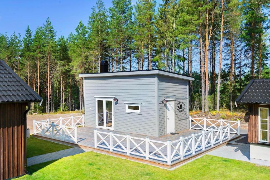 a small grey building on a deck in a yard at Lilla Risingegården in Risinge
