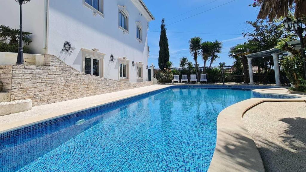 a large swimming pool next to a white building at Silver Coast Pool & Resort Villas in Arnal